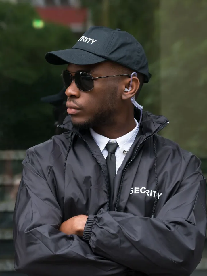Uniformed unarmed security guard standing watch at a corporate building entrance